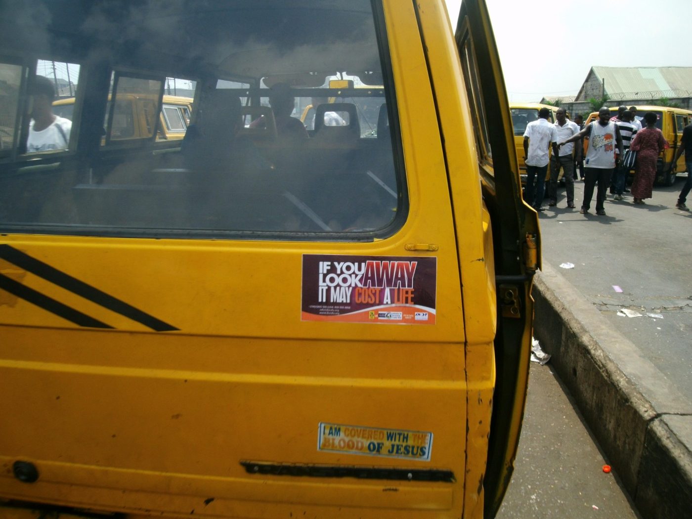 A campaign sticker affixed to a commercial bus at the Tejuosho terminal, carrying the message across Lagos.